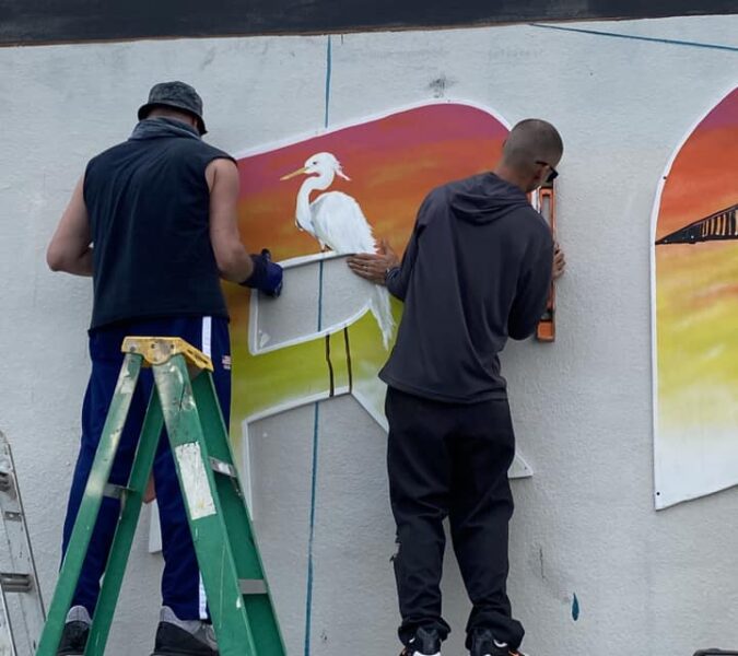 handing giant letters at the bradenton mural
