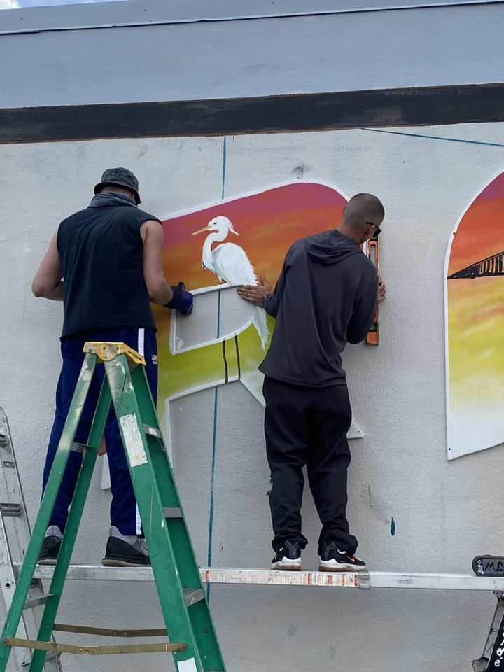 handing giant letters at the bradenton mural